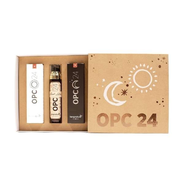 Die OPC 24 Geschenkbox ist ein Naturkosmetik-Geschenkset mit zwei rechteckigen Schachteln und einer Glasflasche, alles in einer kraftfarbenen Verpackung, verziert mit weißen Mond- und Sonnenmotiven und „OPC 24“ auf dem Deckel.