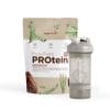 PurePlant PROtein and the shaker_v1.0-Front Ein Beutel Kingnature PurePlant PROtein Schokoladenpulver steht hinter einem Shaker „Blender Bottle Prostak Pro“. Auf dem Beutel sind Erbsen und Kakaofrüchte abgebildet, was die pflanzlichen Inhaltsstoffe unterstreicht.